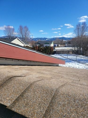 A roof with a red roof and a snowy field in the background.