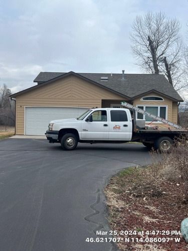 A white truck is parked in front of a house.