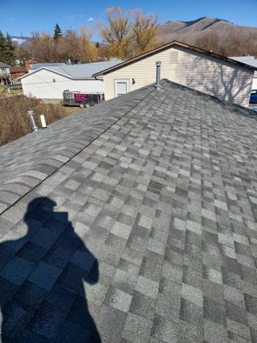 A person is standing on the roof of a house.