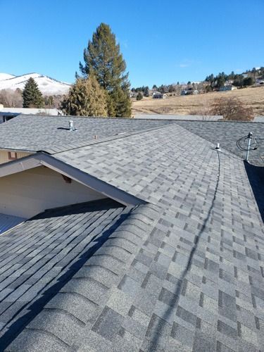 The roof of a house with a gray shingle roof.