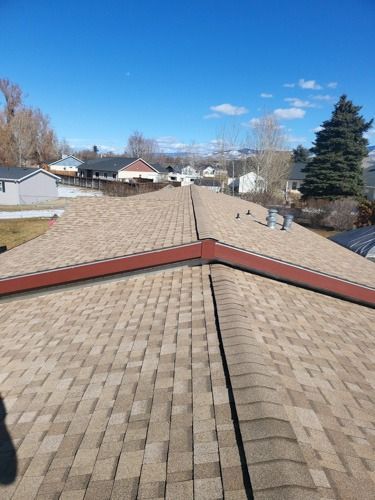 A close up of a roof with shingles on a sunny day.