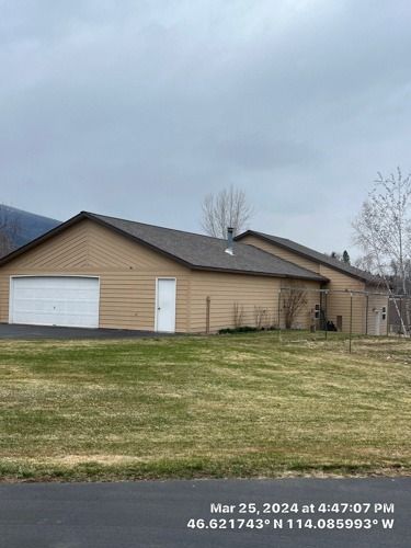 A large house with a garage and a lot of grass in front of it.