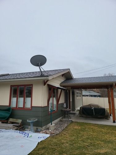 A small house with a satellite dish on the roof.