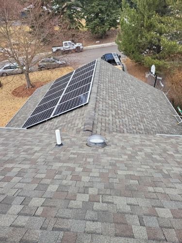 A roof with solar panels on it and a skylight.