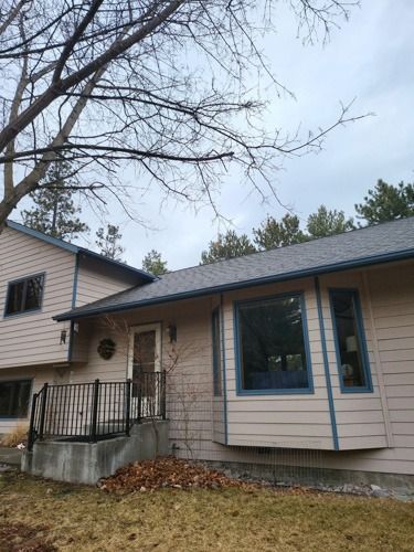 A house with a lot of windows and a tree in front of it.