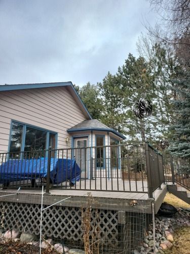 A house with a deck and a gazebo in front of it.