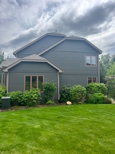 A large house with a lush green lawn in front of it.