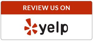 A red and white sign that says review us on yelp