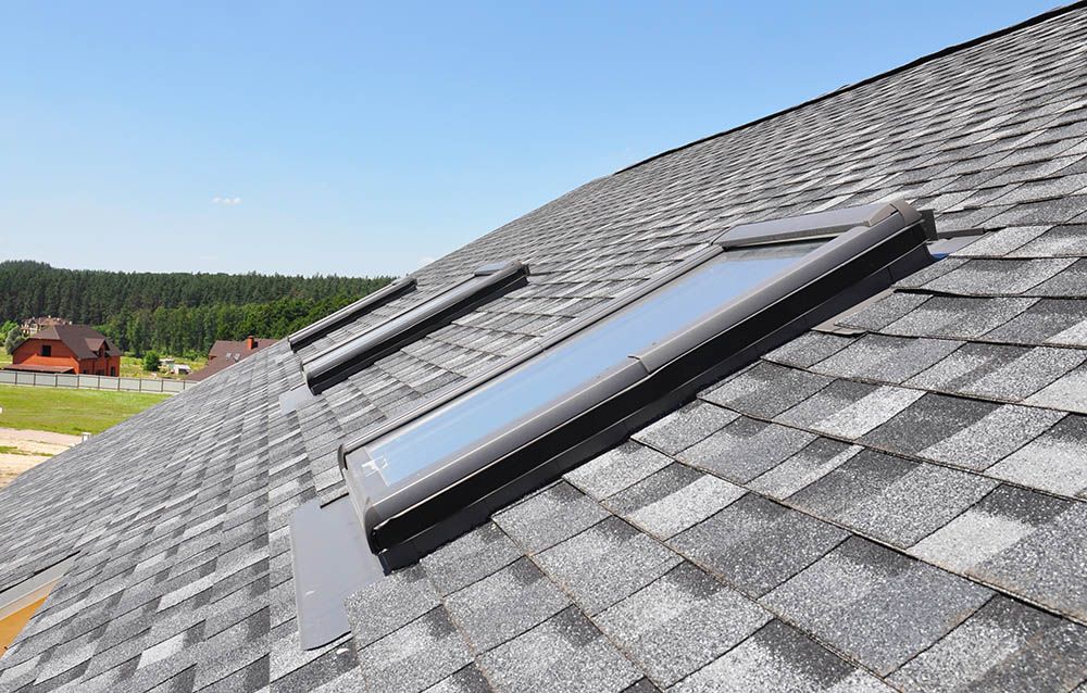 There are two skylights on the roof of a house.