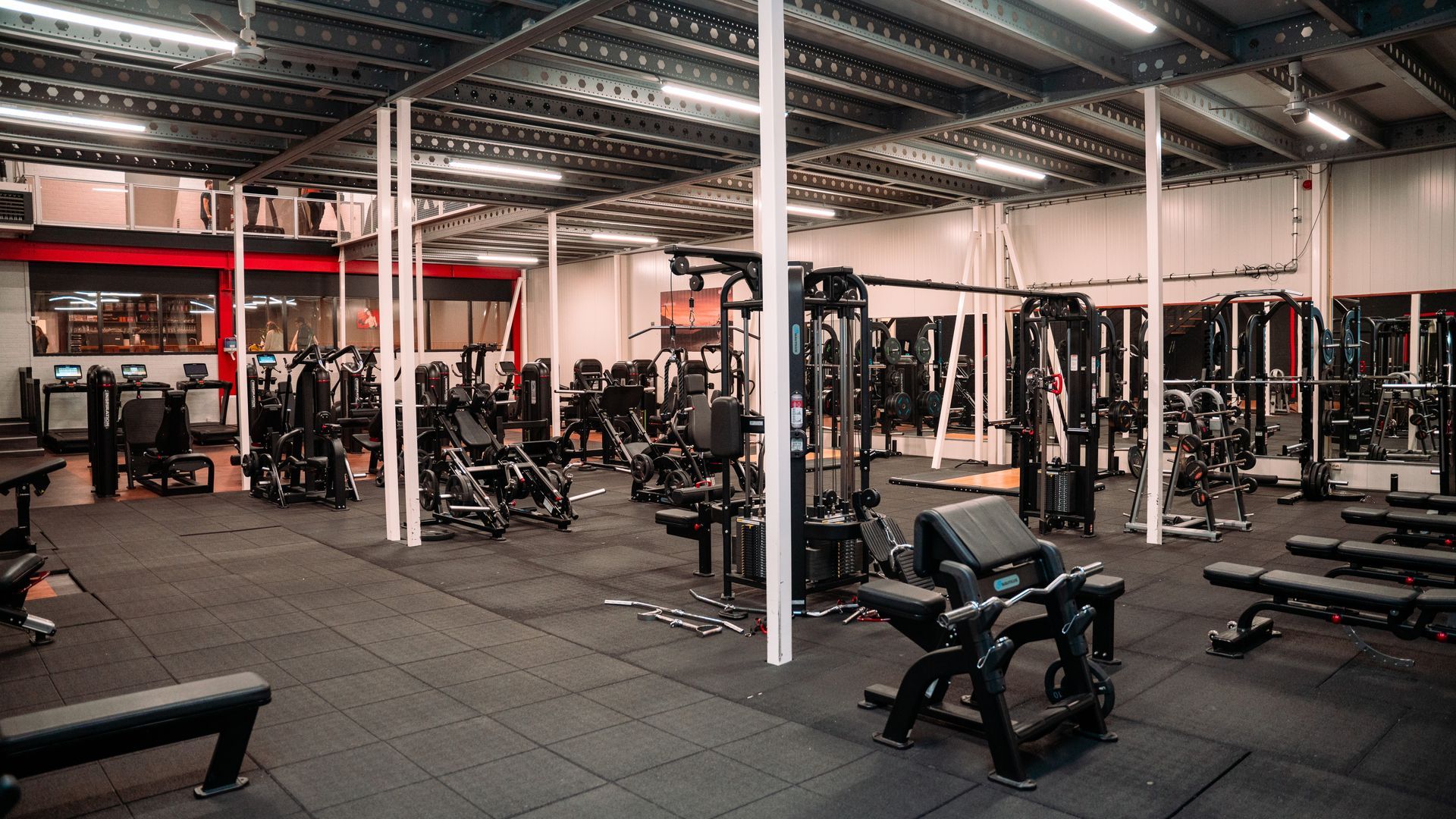 Een grote sportschool vol met fitnessapparatuur.