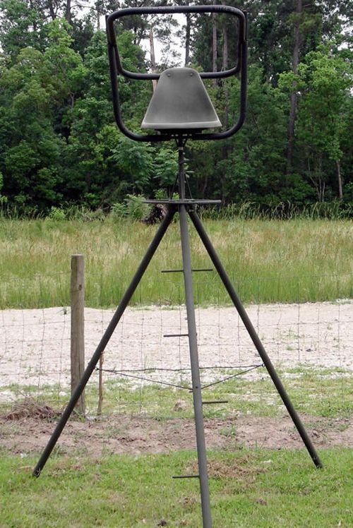A tripod is sitting in the middle of a grassy field.