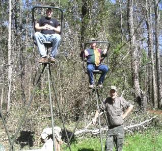 Three men are sitting on a ladder in the woods.