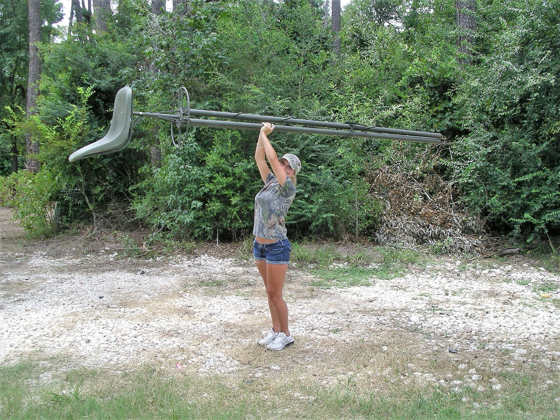 A woman is holding a very long object over her head.