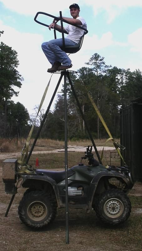 A man is sitting on top of an atv holding a saw