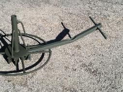 A metal object is sitting on top of a gravel road.