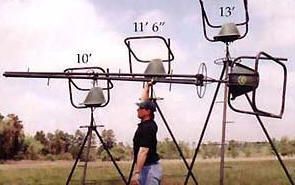 A man is standing in a field next to a very large object.