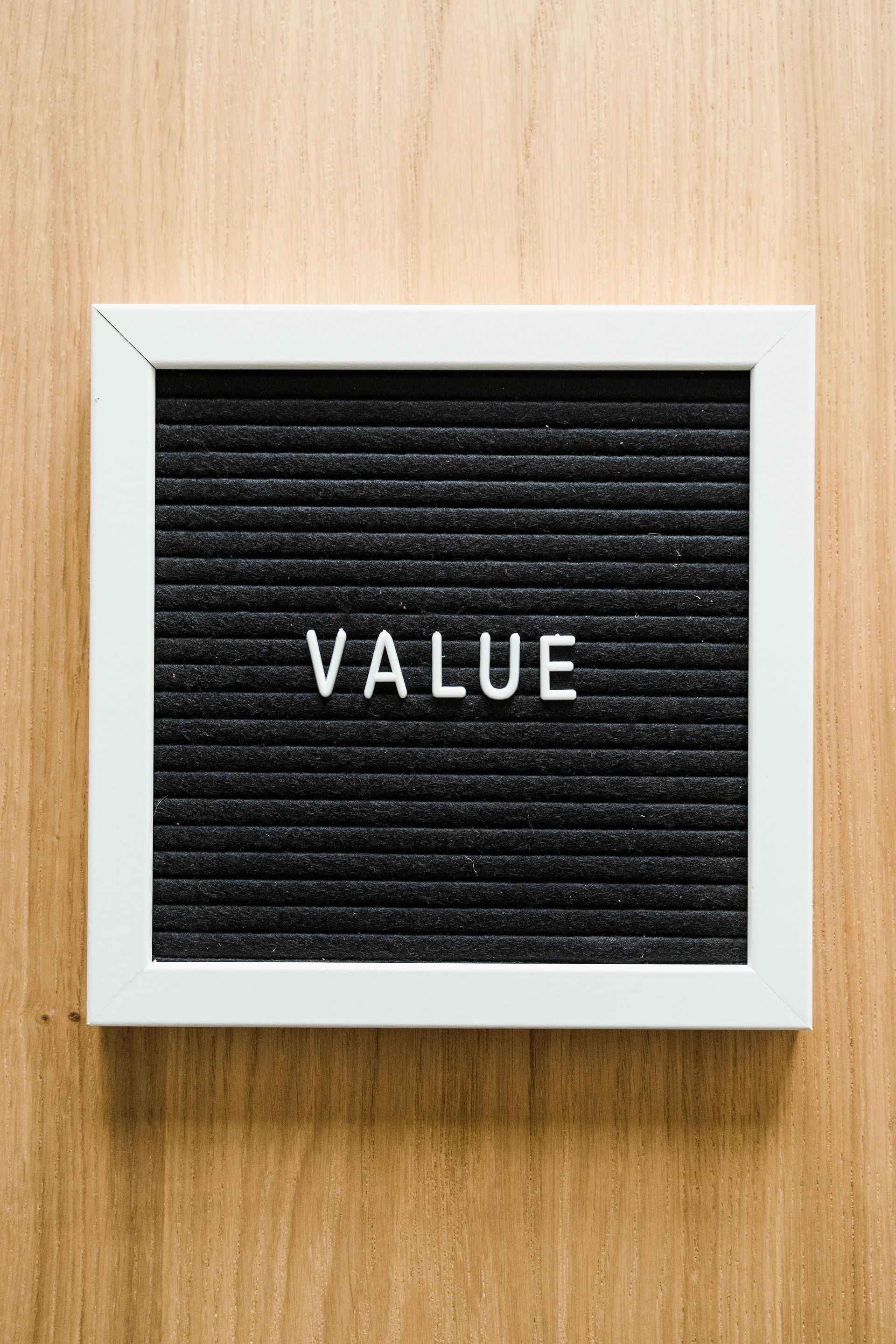 A black letter board with the word value written on it.