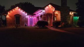 A house with christmas lights on it at night.