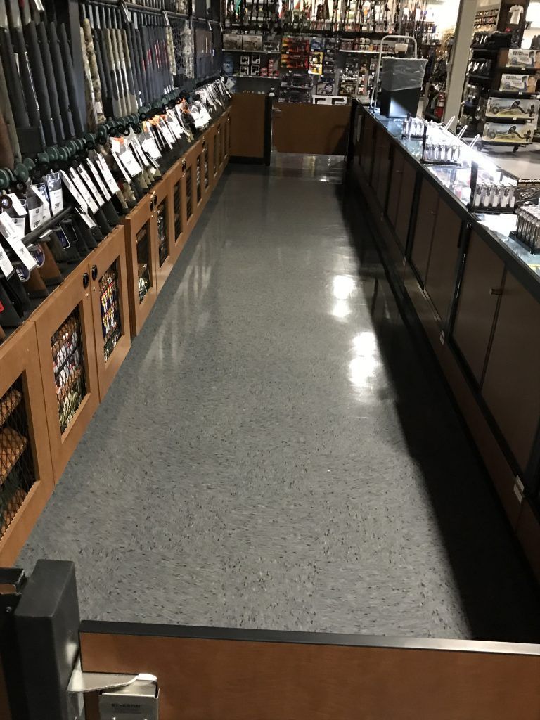 A long hallway in a store with lots of shelves and counters.