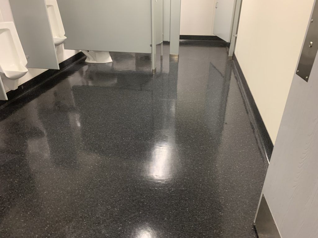 A bathroom with a black floor and white walls