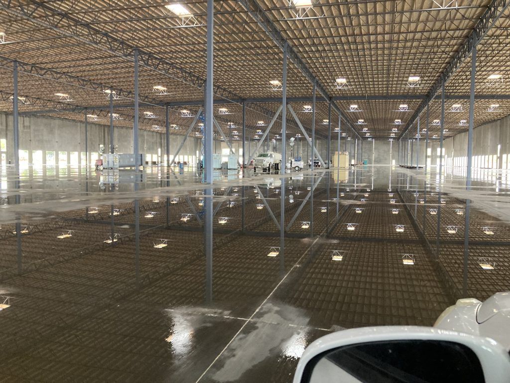 A large empty warehouse with a lot of lights on the ceiling.