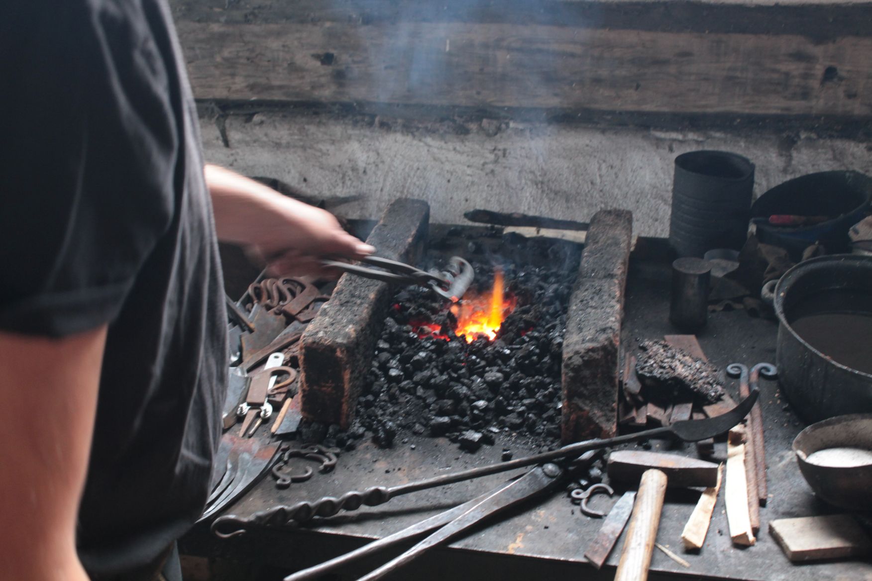 Ein Mann im schwarzen Hemd arbeitet an einem Stück Metall