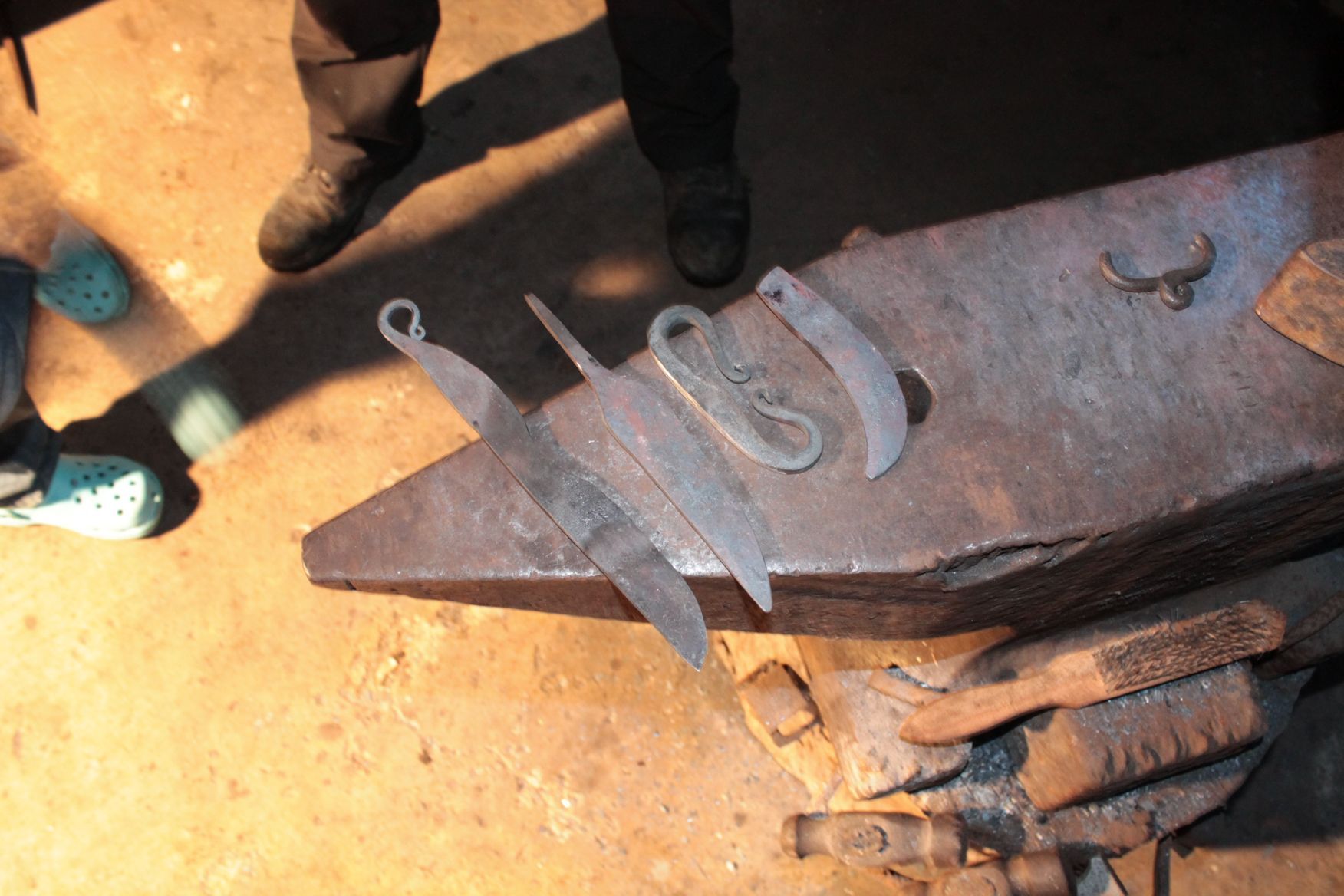 Ein Bündel Messer liegt auf einem Amboss