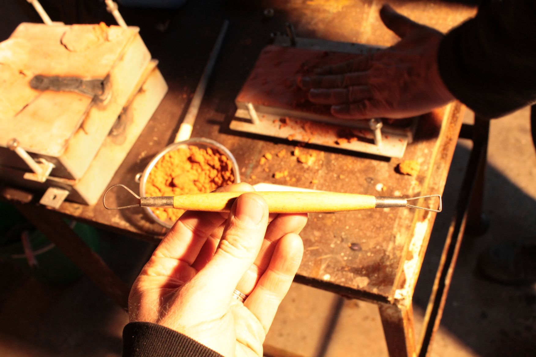 Eine Person hält ein Holzwerkzeug in der Hand
