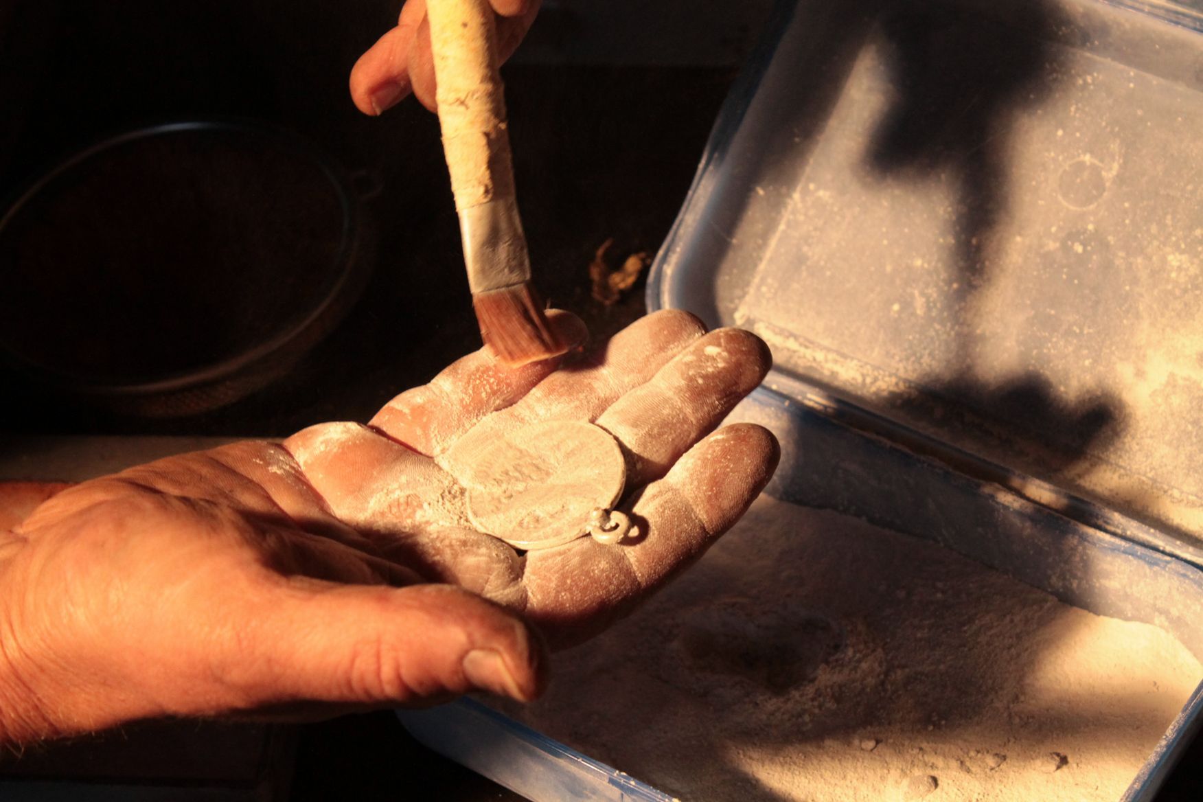 Eine Person hält ein Stück Ton in der Hand