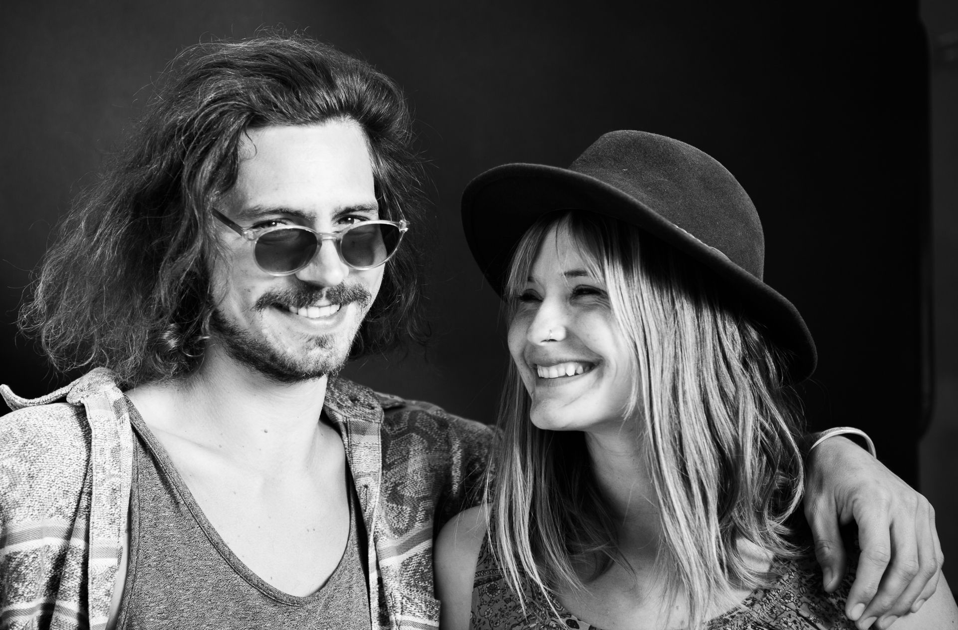 Robert Liedtke and Anka Liedtke Photo Squad 711 A man and a woman pose for a black and white photo. They are wearing a hat and sunglasses.
