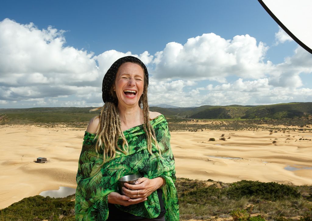 Portät einer Frau mit blonden Dreadlocks vor einer Düne am Meer an der Algarve in Portual