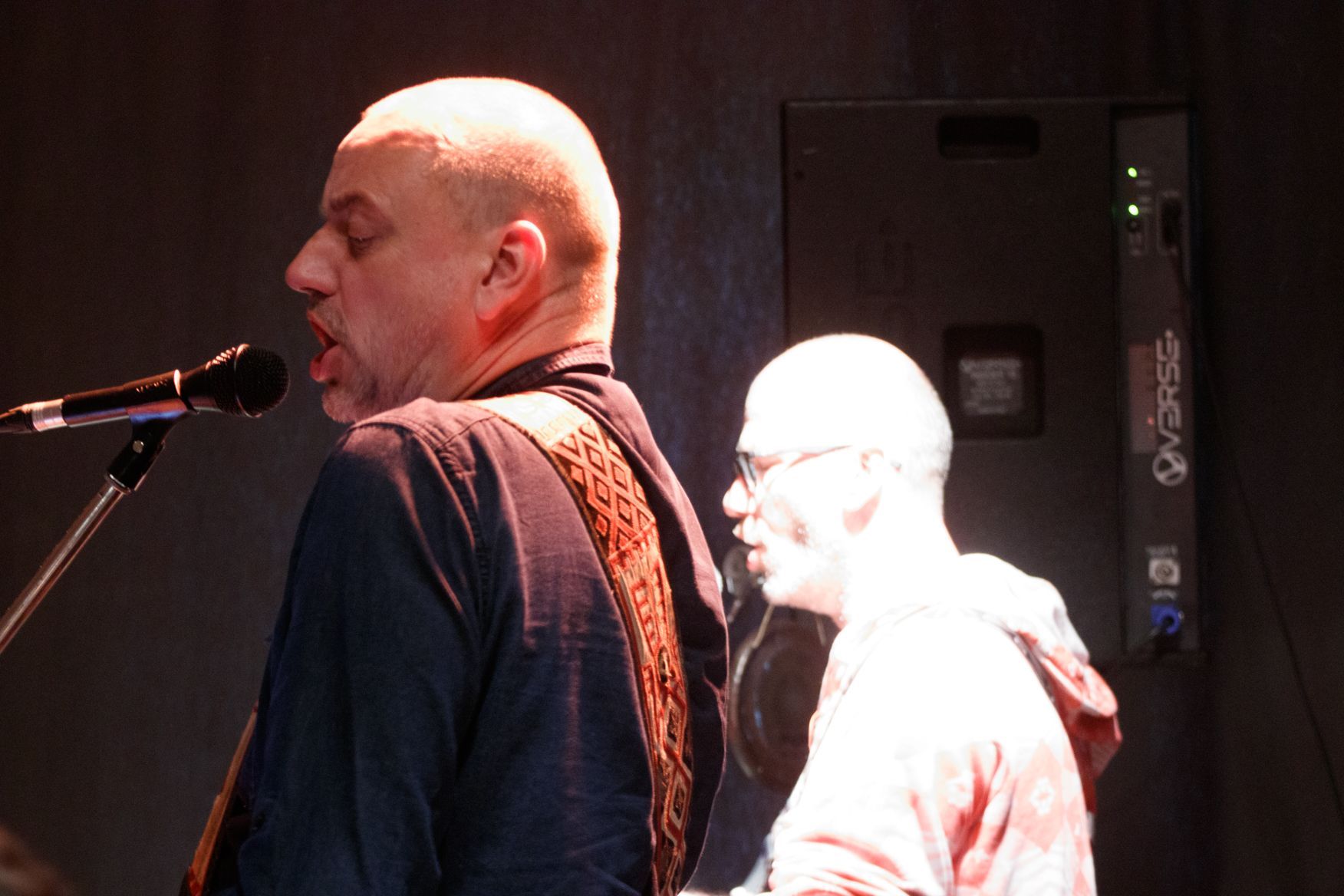 Ein Mann, der neben einem anderen Mann in ein Mikrofon singt