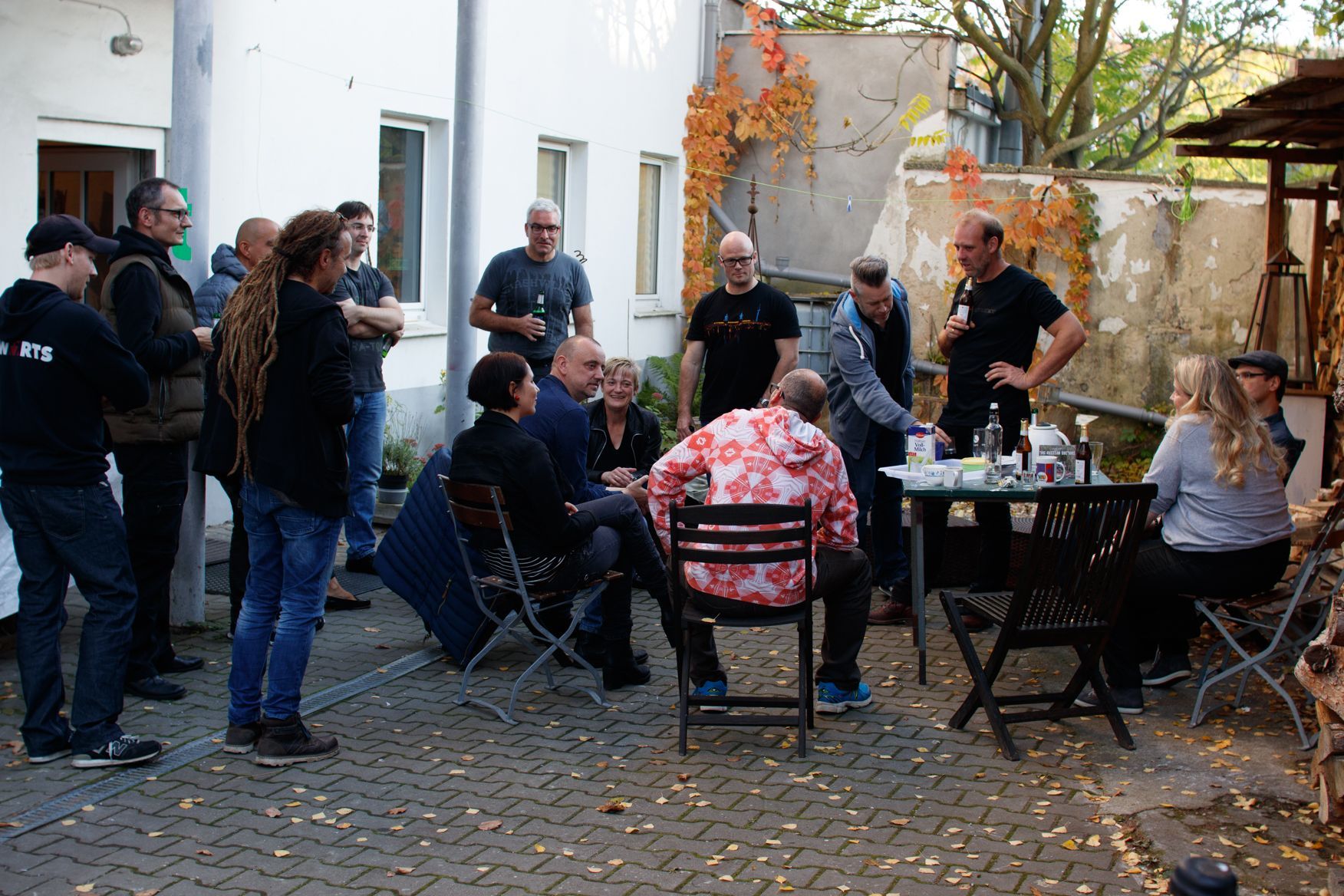 Eine Gruppe von Menschen versammelt sich um einen Tisch und Stühle draußen