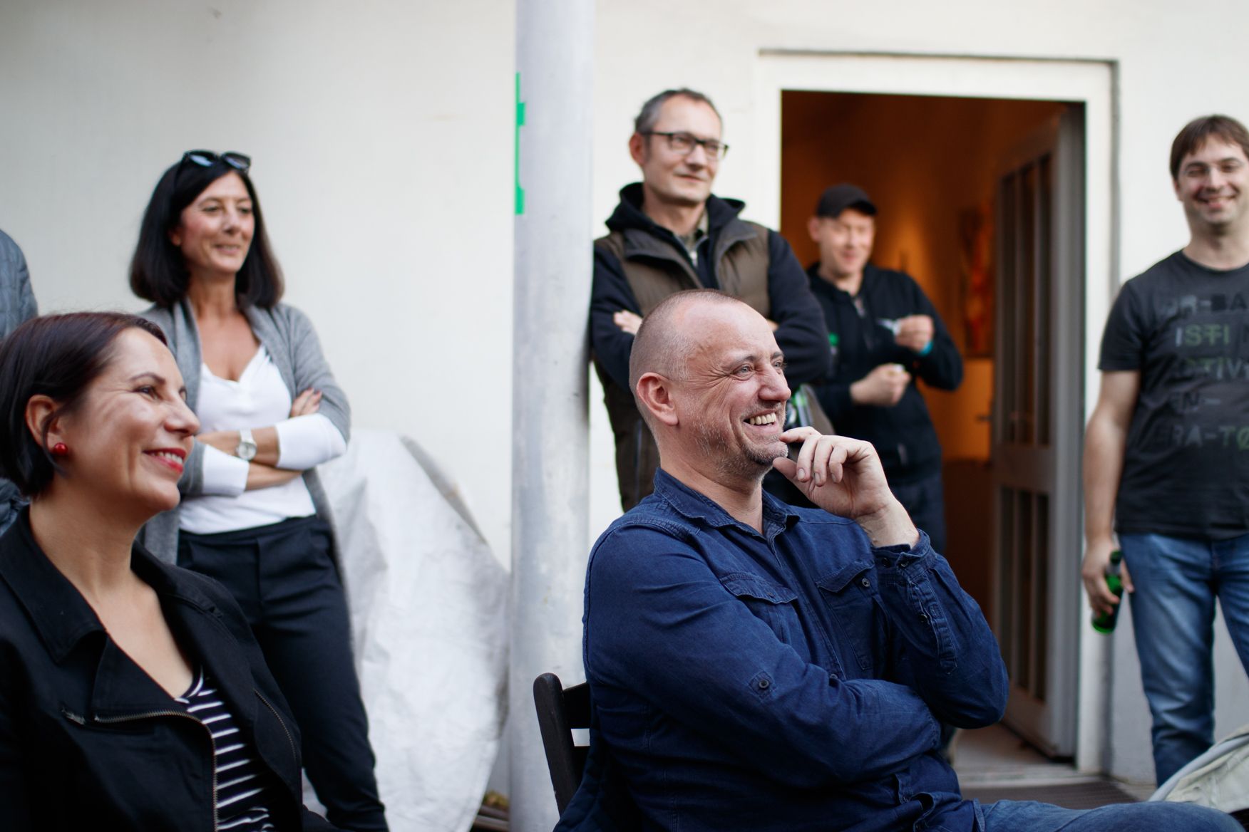 Ein Mann in einem blauen Hemd unterhält eine Gruppe von Leuten
