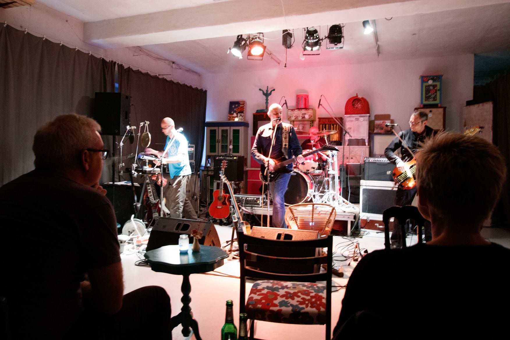 Eine Gruppe von Leuten schaut einer Band auf der Bühne zu