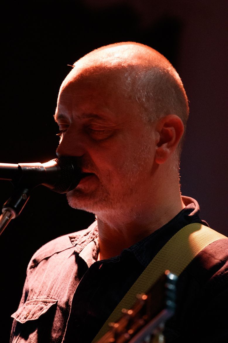 Ein Mann, der mit geschlossenen Augen in ein Mikrofon singt