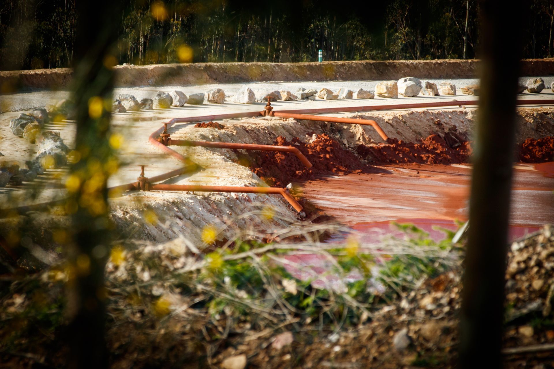 Ein unscharfes Bild einer Baustelle mit ein paar Bäumen im Vordergrund