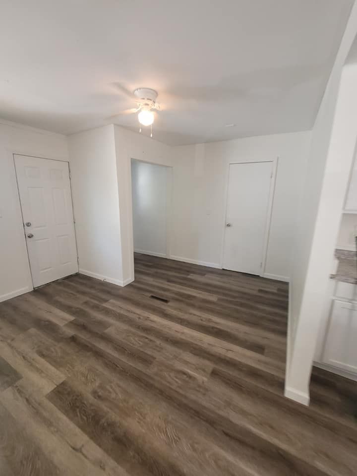 A living room with hardwood floors and a ceiling fan.