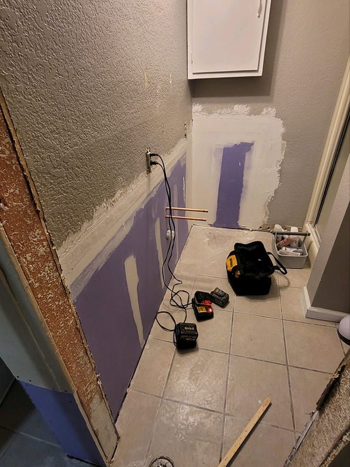 A room with a purple wall and a toolbox on the floor.