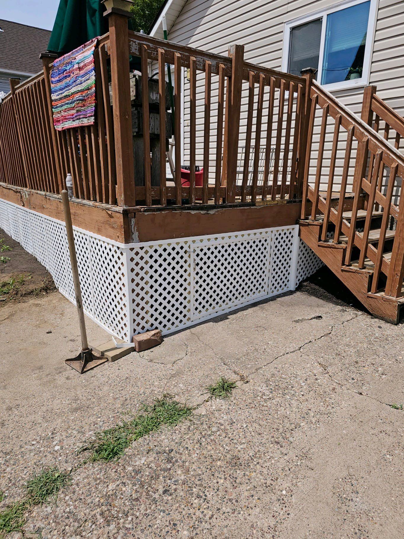 A wooden deck with stairs leading up to it next to a house.