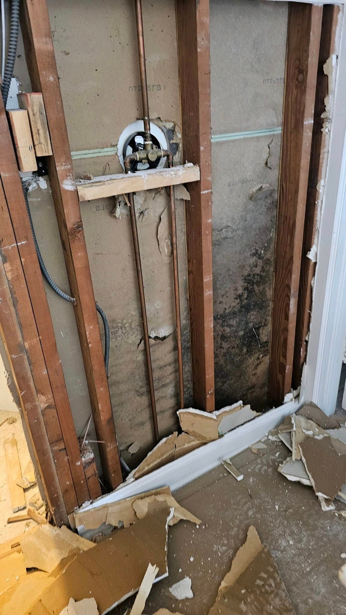 A wooden wall with a hole in it is being remodeled.