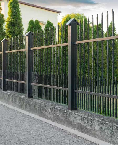 Beautiful black iron fence near pathway outdoors 
