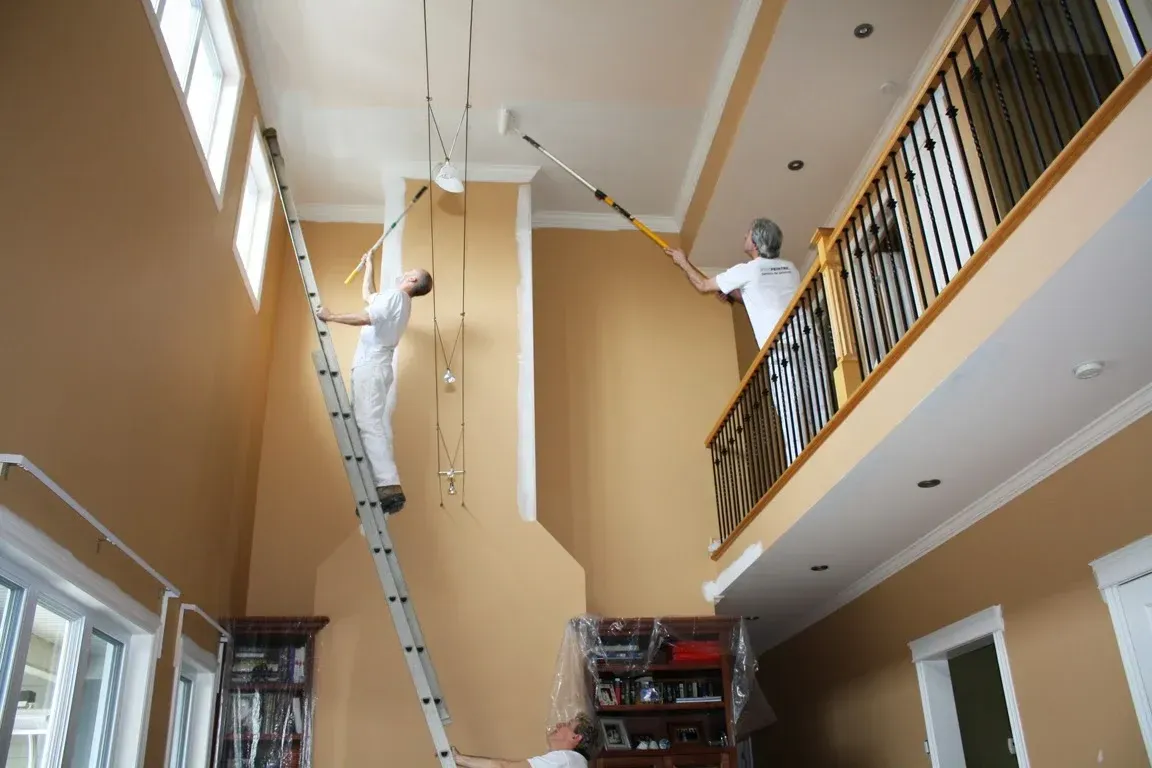 Peintre professionnel appliquant une couche uniforme de peinture sur mur intérieur