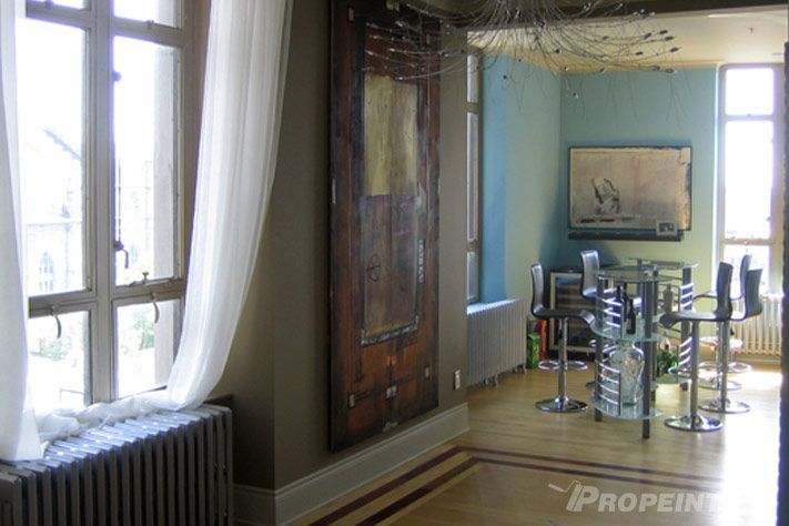 Murs beiges appliqués par Propeintre avec outils spécialisés pour un fini uniforme