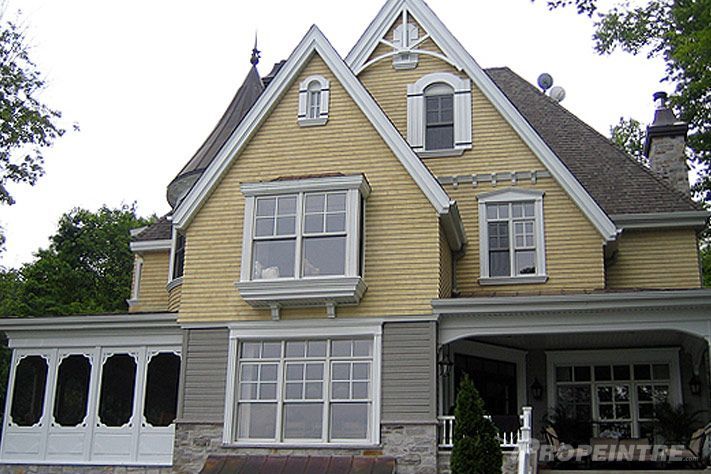 Peinture extérieure traditionnelle sur maison jaune avec grande porte de garage