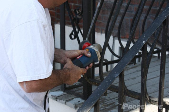 Dernière retouche avec outil de précision sur rampe en fer forgé