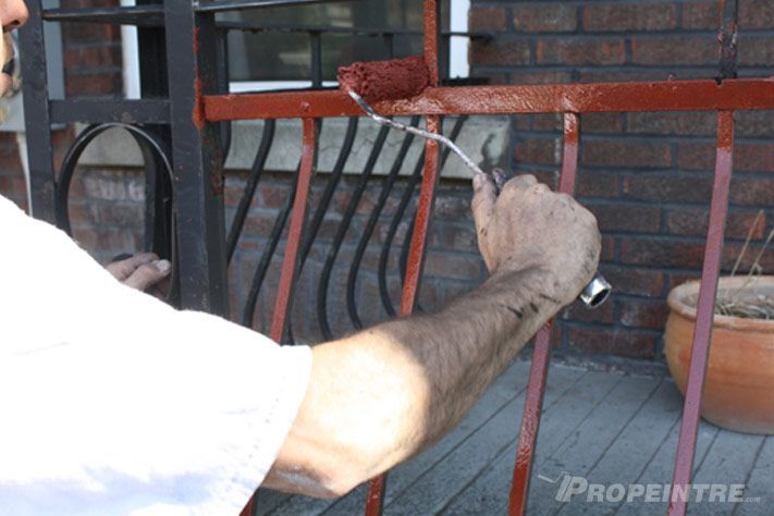 Deuxième couche de peinture appliquée sur rampe en fer forgé