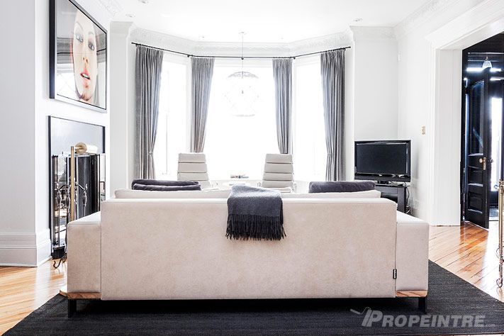 Un salon avec un canapé blanc et un tapis noir, peinture professionnelle résidentielle