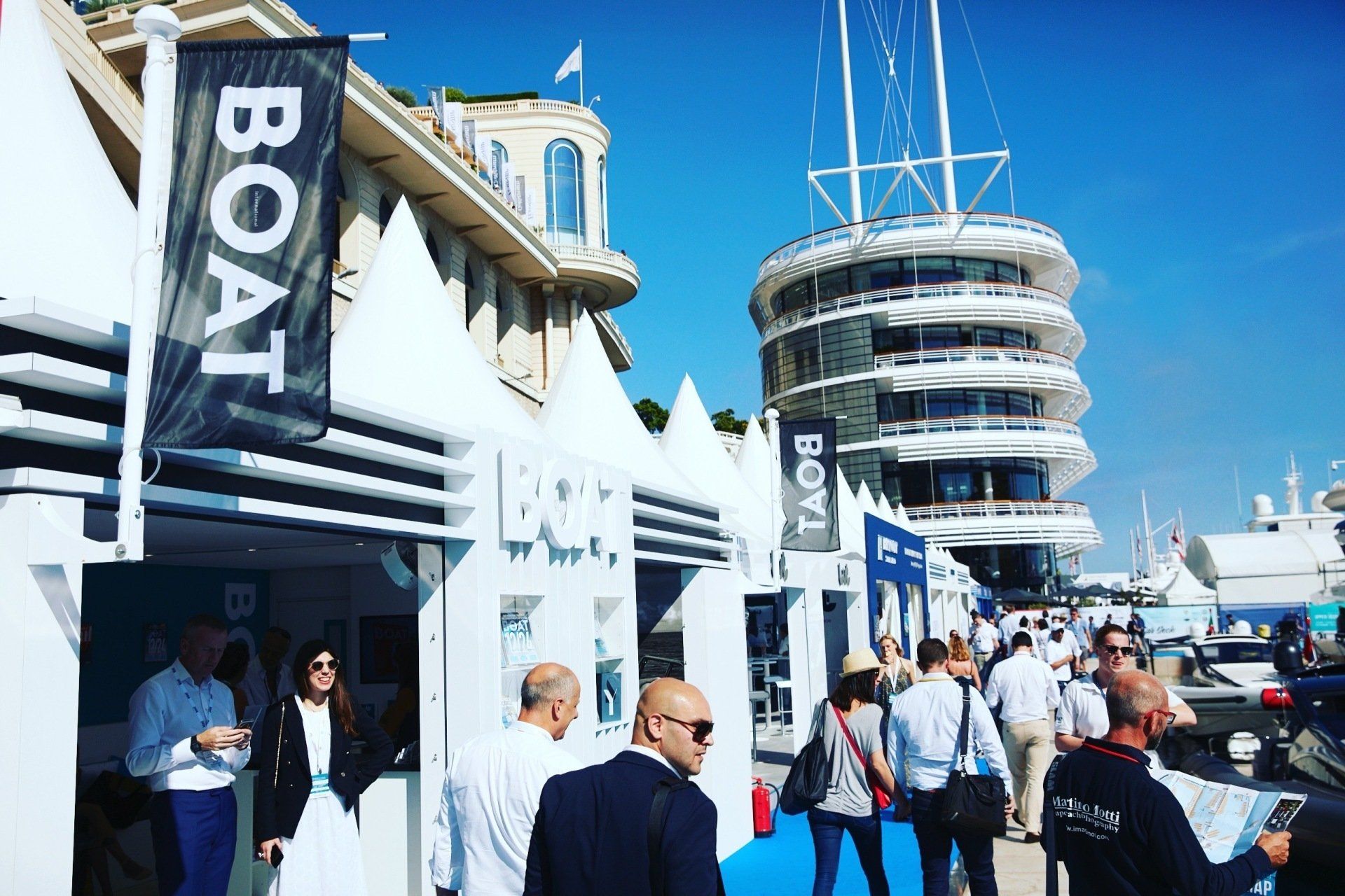 A group of people are standing in front of a booth that says boat.