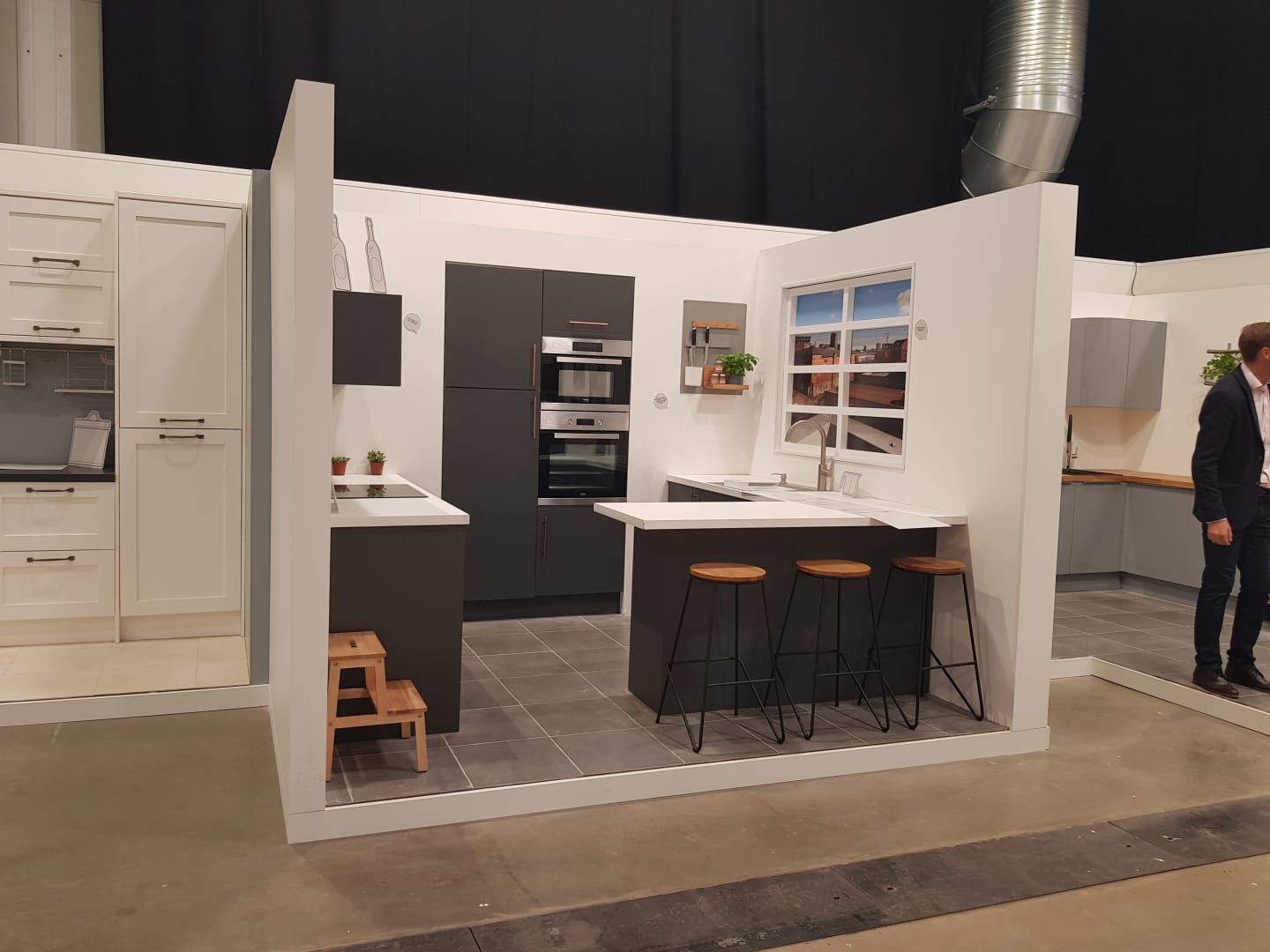 A man is standing in front of a kitchen display.